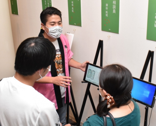 来場者に研究成果を発表する沢田さん（奥）＝岡崎市岡町の愛知産業大で