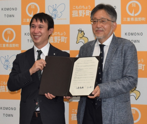 締結書に署名した柴田町長（左）と岩崎学長＝菰野町役場で