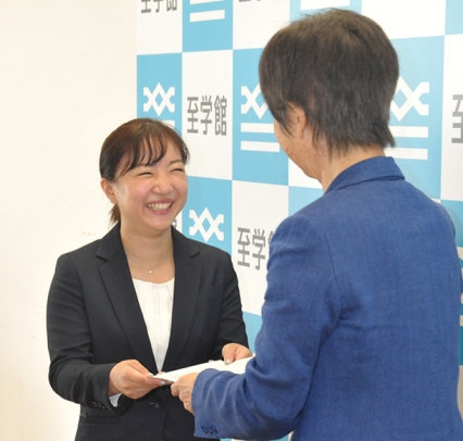 辞令交付を受け、笑顔を見せる寺本さん（左）＝大府市の至学館大で