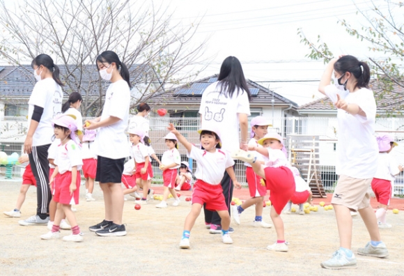 学生に教わり、新聞紙を丸めた特製ボールを力いっぱい投げる園児たち＝各務原市三井山町のみどり幼稚園で