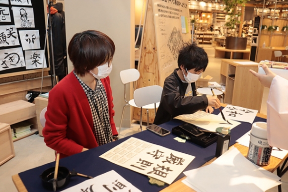 書でオリジナルカレンダー作りを楽しむ来場者＝春日井市六軒屋町で