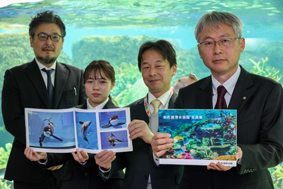 完成した写真集を手にする関係者たち(右から飯田館長、栗田館長、池ケ谷さん、伊藤教授)=港区の名古屋港水族館で