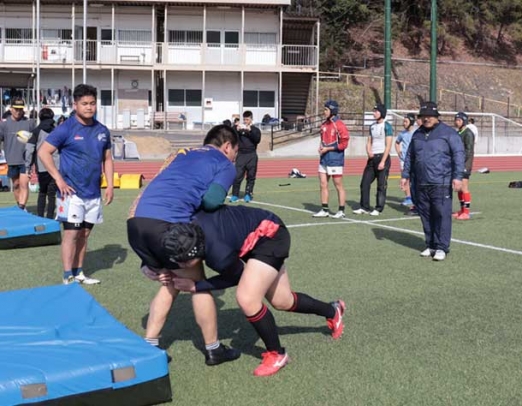 中部大生とタックル練習をする生徒＝春日井市松本町の中部大で