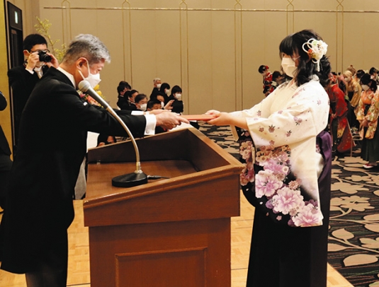 柴田学長（左）から学位記を受け取る卒業生代表者＝四日市市安島１の都ホテル四日市で