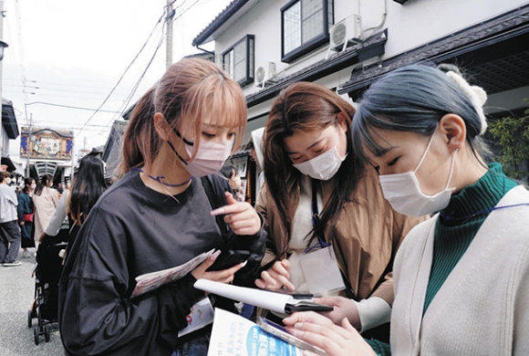 協力し合って謎解きに挑戦する参加者＝長浜市元浜町で