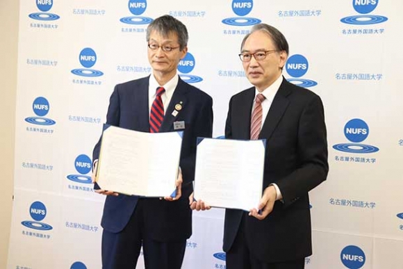 協定書を交わした亀山学長（右）と飯田教育長＝日進市岩崎町の名古屋外国語大で