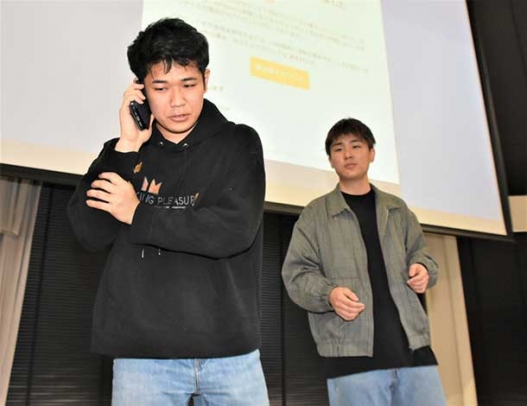 フィッシング詐欺の被害に遭う若者を演じた演劇同好会の部員＝南区の大同大で