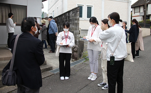 住民らの話をメモする学生たち＝四日市市あかつき台で