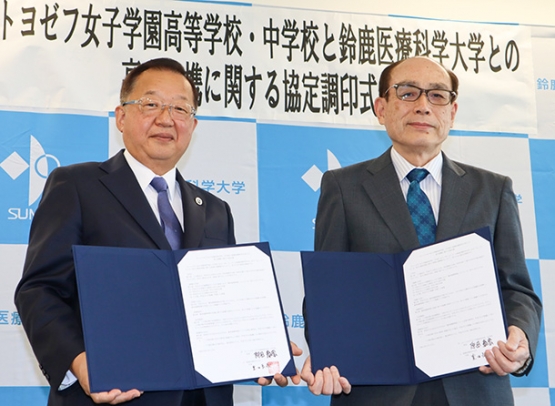 協定書を手にする原田校長(左)と豊田学長=鈴鹿市の鈴鹿医療科学大で