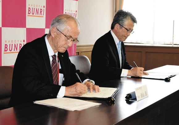 協定書を交わす景山学長（左）と安藤校長＝稲沢市の名古屋文理大で