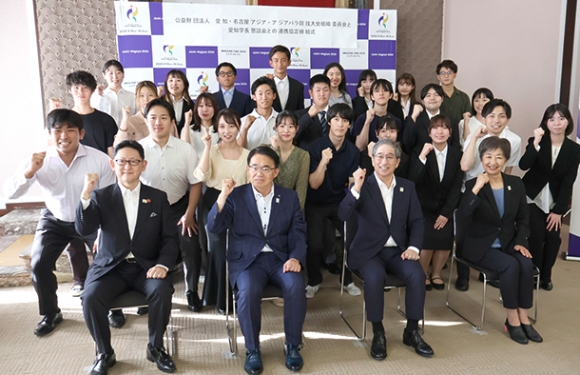 連携協定を結んだ組織委会長の大村知事（前列左から２人目）と名古屋大の杉山学長（前列左から３人目）、締結式に参加した大学生ら＝県庁で