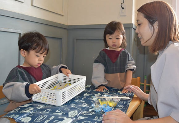 ウルラが贈ったスモックを着て工作をする園児たち＝日進市梅森台のメモリーツリー梅森台保育園で