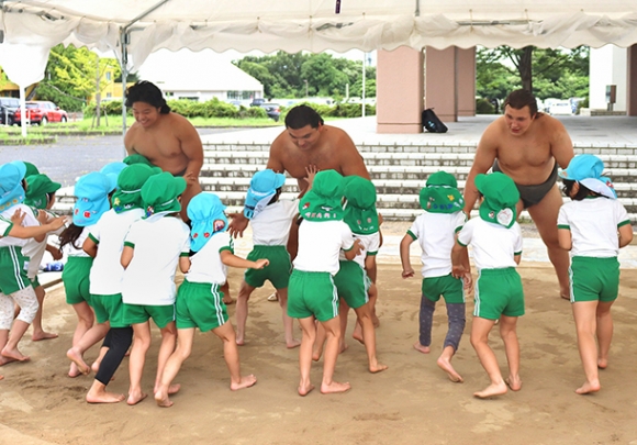 園児と相撲を取る安治川部屋の力士たち＝愛知県犬山市の名古屋経済大で