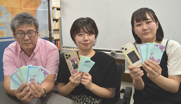 「推しごとシール」のアイデアを出した井藤さん（右端）と竹内さん（右から２人目）、宮川教授＝日進市の名古屋外国語大で