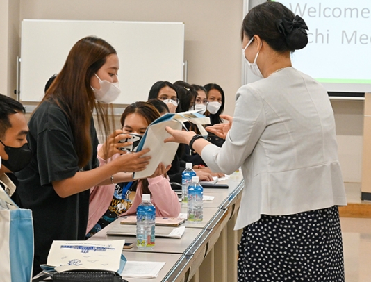 坂本看護学部長（右）から記念品を受け取る留学生＝長久手市岩作雁又の愛知医科大で