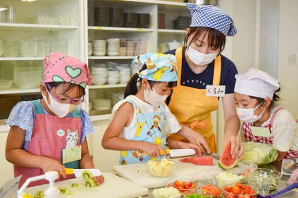 学生に教えてもらいながら料理に挑戦する子どもたち＝日進市の愛知学院大で