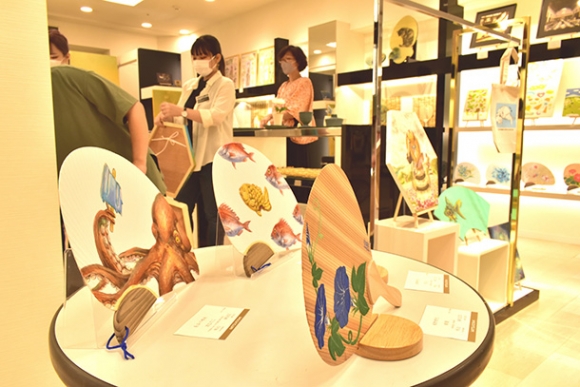 婦人ファッション用品が並ぶ一角に展示した名古屋造形大の学生、卒業生らの作品=栄の名古屋三越栄店で