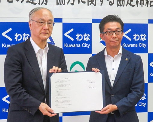 協定書を手にする愛知大の川井学長（左）と三重県桑名市の伊藤市長＝桑名市役所で