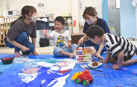 学生たちと一緒に作品づくりを楽しむ子どもたち＝日進市栄の「ａｎｄにこり日進」で