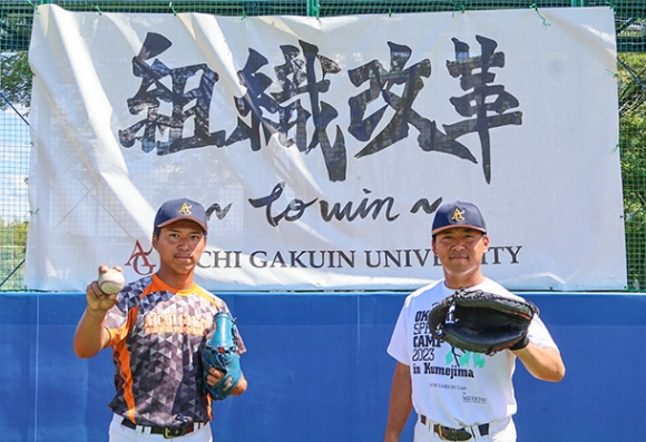 今年のスローガンの前で意気込む愛院大の三島有主将（右）と三島安投手＝愛知学院大学野球場で（後藤正樹撮影）