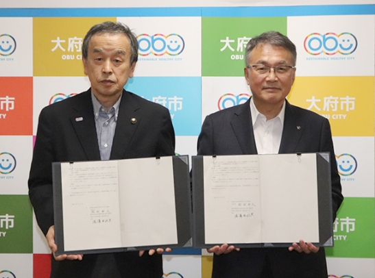 協定書を手にする岡村市長(左)と湯沢学長=大府市役所で