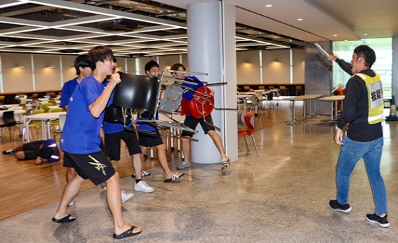 刺された学生を守るため、椅子を使って不審者との距離をとる学生ら＝南区の大同大で