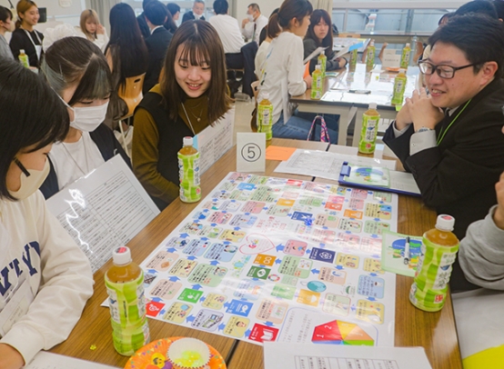エシカル消費を学べるすごろくで遊ぶ学生と東海農政局職員＝天白区の東海学園大名古屋キャンパスで