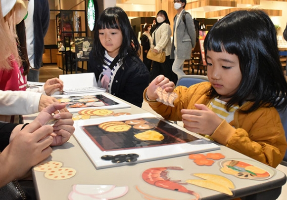 おせち料理の盛り付けを考える子どもたち＝稲沢市のアピタ稲沢店で