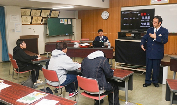 闇バイトの危険性について署員（右）の説明を聞く学生たち＝緑署で