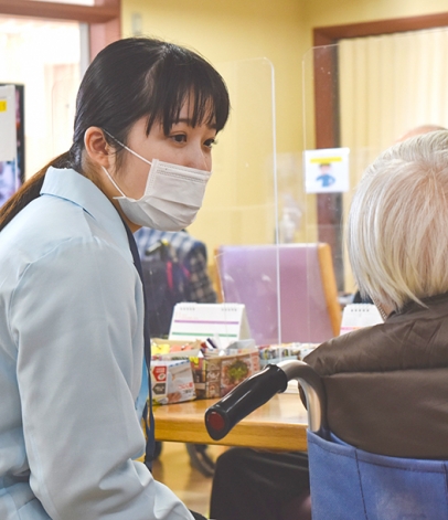 ボランティアとして入所者の話し相手になる学生＝日進市米野木町の愛泉館で