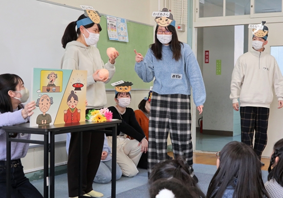 桃太郎を題材に認知症について伝える愛知淑徳大の学生たち＝千種区の千代田橋小で