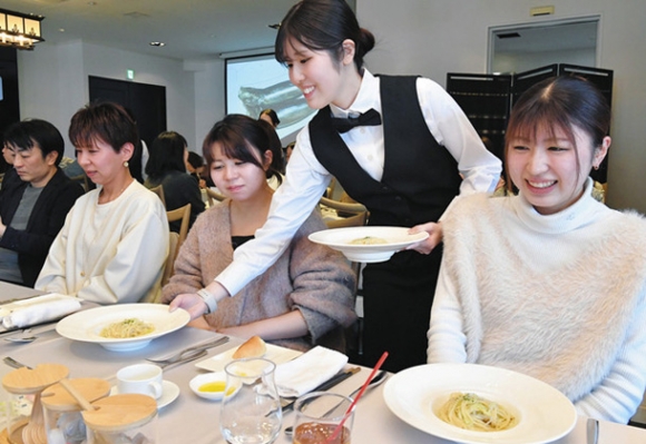 「説明が長い料理店」で来店者に料理を提供する学生スタッフ＝中村区名駅南の「エルダンジュ名古屋」で