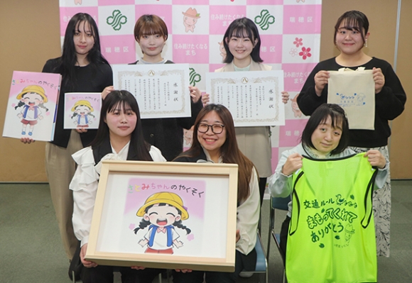 絵本やビブスを手に笑顔を見せる学生ら=瑞穂区役所で