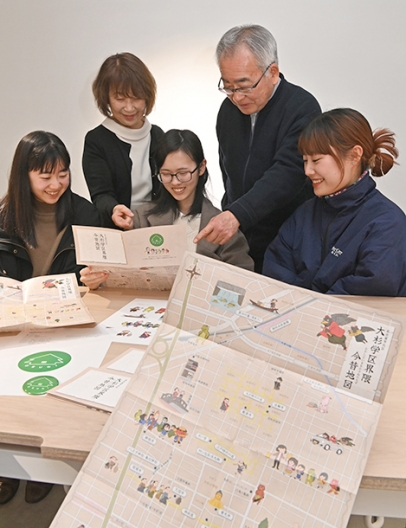 完成した「大杉学区界隈今昔地図」を見る「大杉まちづくり会」のメンバーと名古屋造形大の学生たち＝北区の同大で
