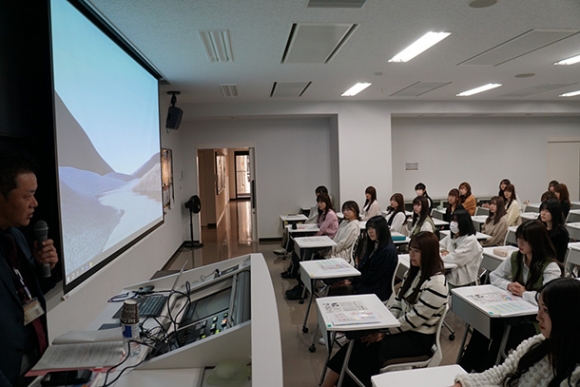 千種署生活安全課員（左）の話を聞く学生ら＝千種区の愛知学院大短期大楠元キャンパスで