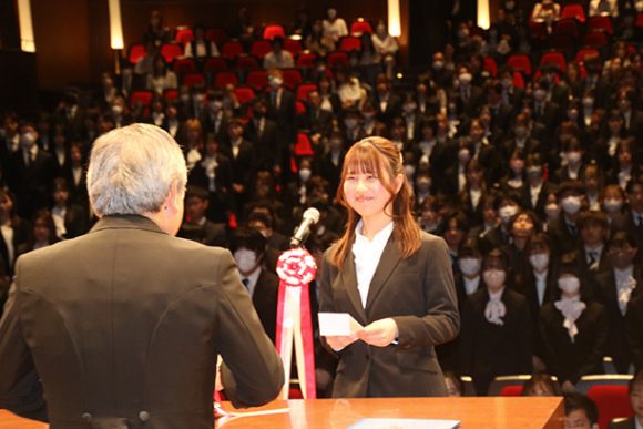 新入生代表あいさつをする牧野さん＝可児市文化創造センターで