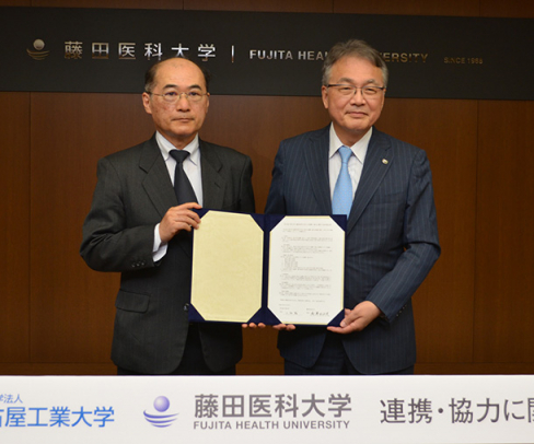 協定書を手にする藤田医科大の湯沢学長（右）と名古屋工業大の小畑学長＝豊明市の藤田医科大で