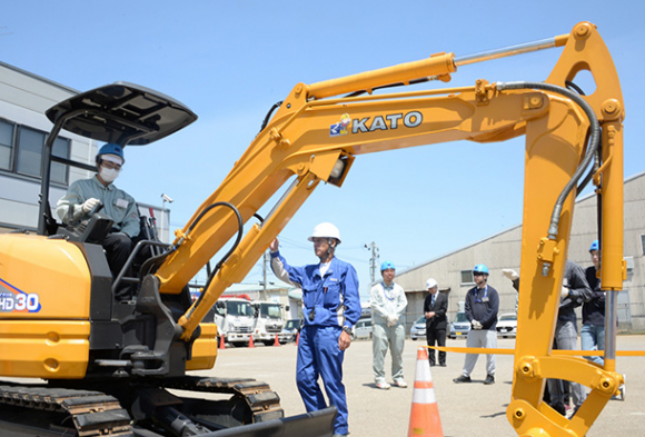 ミニショベルカーに乗り込み、操作を学ぶ学生＝金沢市湊で