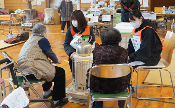 石川県穴水町の避難所で高齢者と会話する藤田医科大の学生＝同大提供