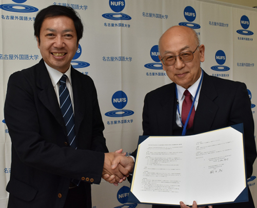 鈴木学部長（右）と握手するＶＦＪ代表理事の小松さん＝日進市の名古屋外国語大で