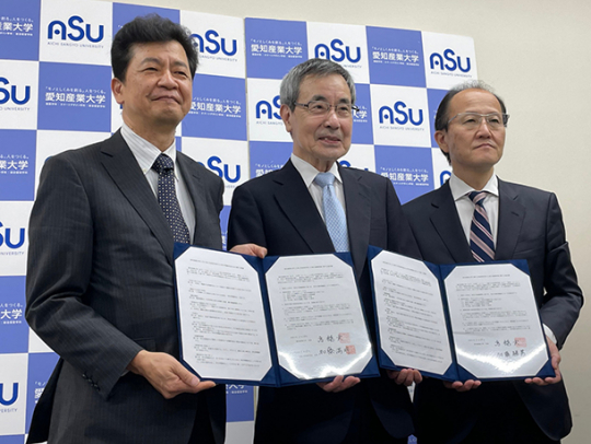 協定書に署名した高橋学長（中）ら３校の関係者＝岡崎市岡町の愛知産業大で
