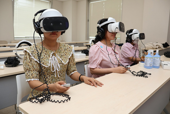 ＶＲで水害を疑似体験する学生たち＝関市桐ケ丘の中部学院大関キャンパスで