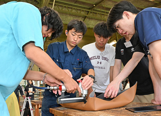 中日青葉学園のいすの布地を張り替える名古屋聾学校の生徒(左から2人目)と名城大の学生=名古屋市千種区で