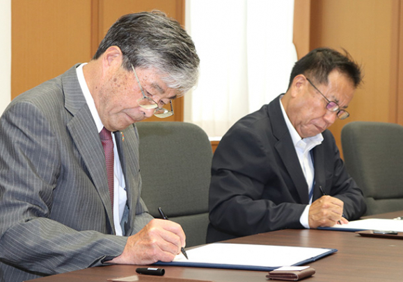 協定書に署名する江馬学長(左)と香田教育長=揖斐川町役場で