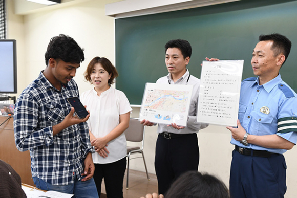 １１０番通報を体験する留学生（左）＝瑞穂市穂積の朝日大で