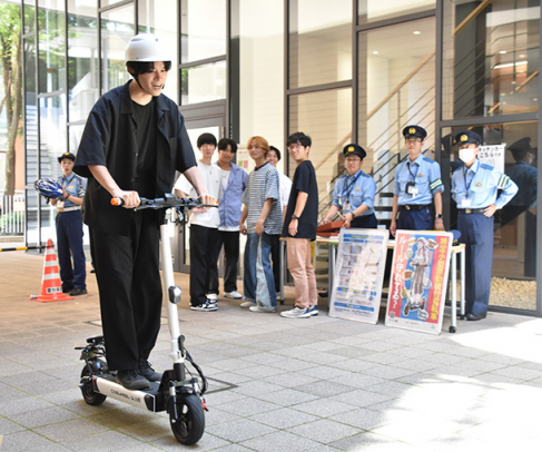 電動キックボードに試乗する学生＝名東区の愛知東邦大で