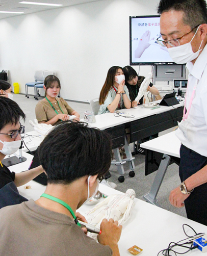 人体のつぼについて学ぶ学生ら＝鈴鹿市の鈴鹿医療科学大で