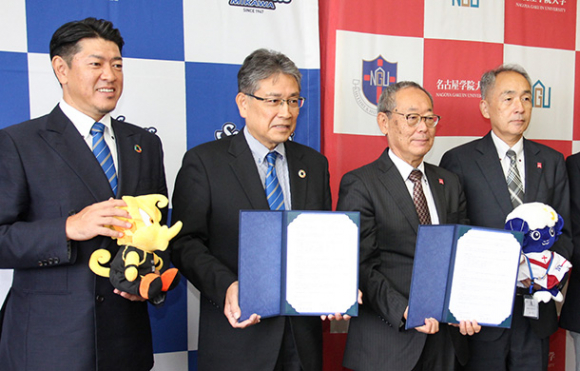 協定を結び、記念写真に納まるシーホース三河の寺部社長(左から2人目)と名古屋学院大の西中理事長(同3人目)ら=熱田区の同大で