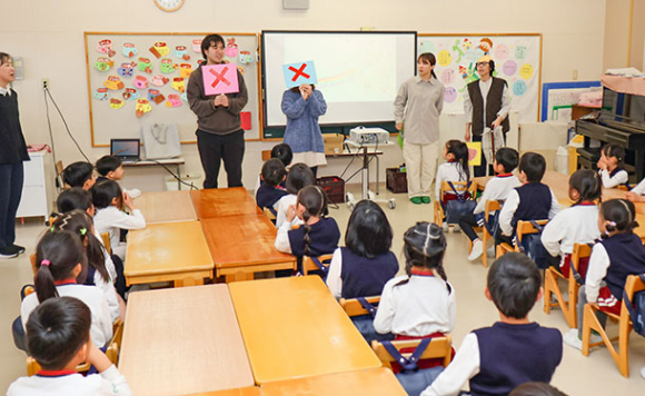 歌やクイズを交えて認知症の人への接し方などを伝える学生ら＝松阪市中央町のまつさか幼稚園で