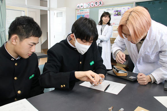 金沢工業大の学生（右）から実験の仕方を教わる生徒＝金沢市高尾台の高尾台中学校で